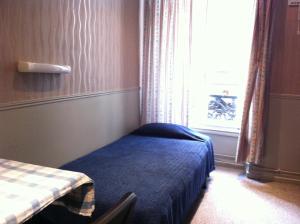 パリにあるホテル デザールのベッドと窓が備わる小さな客室です。