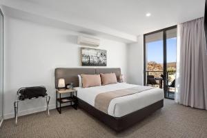古尔本Quest Goulburn的一间带大床的卧室和一个阳台
