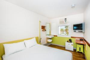 a bedroom with a white bed and white walls at ibis Budget - Dandenong in Dandenong