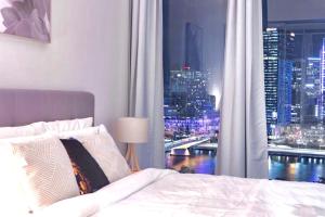 a bedroom with a large window with a city skyline at Lucid Apartment South Brisbane in Brisbane