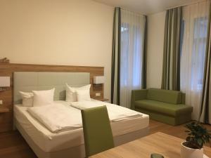 - une chambre avec un lit et une chaise verte dans l'établissement Perkeo Apartments, à Heidelberg