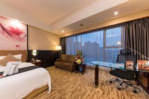 Pokój hotelowy z łóżkiem, biurkiem i oknem w obiekcie KB Hotel Qingyuan w mieście Qingyuan