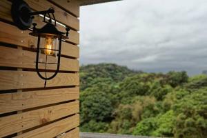 a light hanging on the side of a wooden wall with a window at La Maison Hotel in Taipei