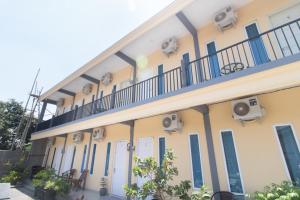 un edificio con puertas azules y balcón en RedDoorz Syariah At Winong Nganjuk, en Nganjuk