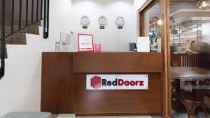 a red door sign in a restaurant with clocks on the wall at RedDoorz Plus @ Diola Villamonte Bacolod in Bacolod