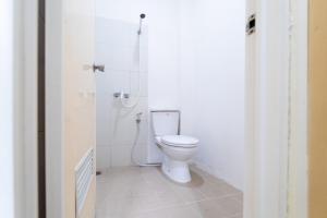 een witte badkamer met een toilet en een douche bij KoolKost near Ragunan Zoo - Minimum Stay 6 Days in Jakarta