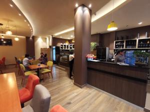 a restaurant with a counter and people sitting at tables at Margarita Apartamentos in Cochabamba