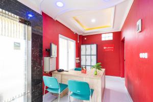 une chambre rouge avec des chaises bleues et un bureau dans l'établissement RedDoorz Syariah near Exit Toll Ciawi, à Bogor