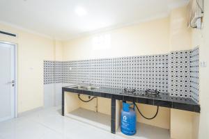 a bathroom with a black counter and a blue bottle at RedDoorz Syariah near Exit Toll Ciawi in Bogor +22 photos