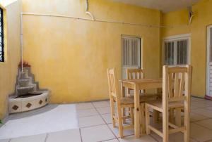 jadalnia ze stołem, krzesłami i kominkiem w obiekcie Posada del Rey Azúcar w mieście Salina Cruz