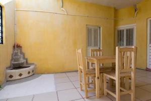 a dining room with a table and chairs and a fireplace at Posada del Rey Azúcar in Salina Cruz