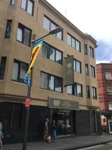 un edificio con una bandera frente a una tienda en UNO Hotel Sydney en Sídney