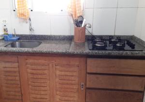 um balcão de cozinha com um fogão e um lavatório em BellaVistaCaraguatatuba - Vista do mar em Caraguatatuba