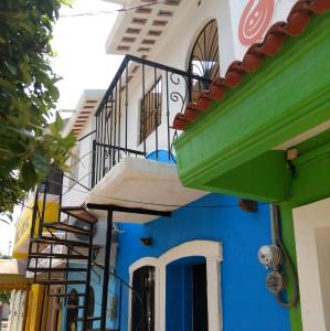 niebiesko-biały budynek z balkonami przy ulicy w obiekcie Posada del Rey Azúcar w mieście Salina Cruz