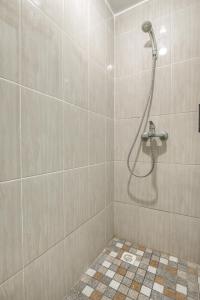 La salle de bains est pourvue d'une douche avec un pommeau de douche. dans l'établissement KoolKost Syariah near Kaza Mall Surabaya, à Surabaya