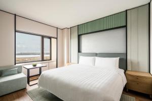 a bedroom with a large white bed and a couch at Shangri-La Harbin in Harbin