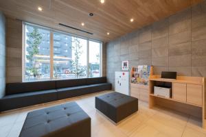 a waiting room with a bench and a window at Just Inn Matsusaka Station in Matsuzaka