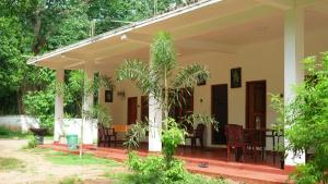 a porch of a house with trees at Punkalasa tourist lodge in Anuradhapura