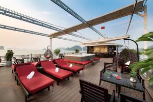 a deck with red chairs and a fireplace on a boat at Athena Royal Cruise in Ha Long