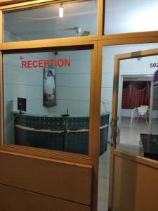 a reflection of a restaurant sign in a glass door at Sai Maa Resort And Convention Centre in Puttaparthi