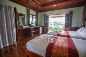 1 dormitorio con 2 camas y baño con espejo. en Yataa Spa and Resort, en Ko Sukon
