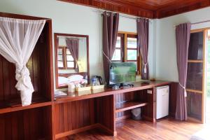 1 dormitorio con TV en un escritorio de madera en Yataa Spa and Resort, en Ko Sukon