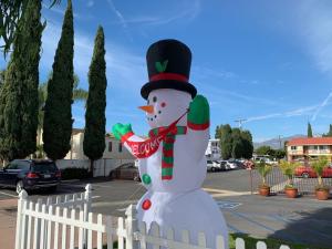 a snowman standing next to a white fence at Valley Hotel in Rosemead