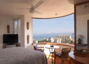 a bedroom with a bed and a view of the ocean at Casa Isabel a Boutique Hilltop Inn in Puerto Vallarta