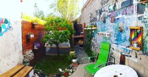 ogród z zielonym krzesłem i ścianą z graffiti w obiekcie Estación Libertad w mieście Perito Moreno