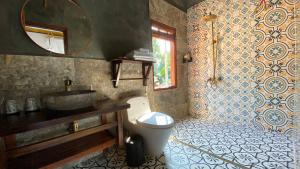 a bathroom with a toilet and a sink and a mirror at Mai Chau Rustic Home in Mai Chau