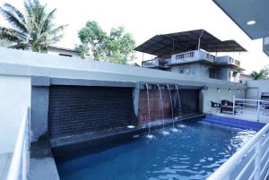a house with a swimming pool with a water fountain at Dean Villa in Lonavala