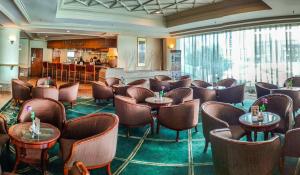 a restaurant with chairs and tables and a bar at Sabah Oriental Hotel in Kota Kinabalu