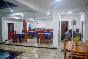 jadalnia z niebieskimi stołami i drewnianymi krzesłami w obiekcie Lion Resort w mieście Polonnaruwa