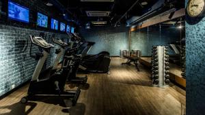 a gym with cardio equipment and a clock on the wall at Hotel Gin Bugis Singapore - previously Hotel G in Singapore