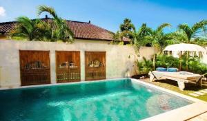 a swimming pool in front of a house at Villa Sarong 2 in Seminyak