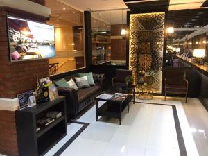 a living room with a couch and a tv at Buddy Lodge, Khaosan Road in Bangkok