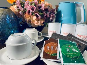 a table with cups and a tea pot and flowers at Kingdom Hotel in Hsinchu City