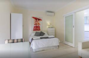 a white bedroom with a bed and a large window at M102 West Perth Studio Apartment near Kings Park in Perth