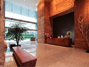 a lobby with a wooden bench in a building at Oasia Hotel Novena, Singapore by Far East Hospitality in Singapore