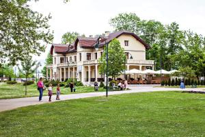 Una donna e due bambini che camminano davanti a un palazzo di Hotel Hercegovina a Sarajevo