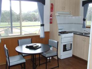 a kitchen with a table and chairs and a stove at Western KI Caravan Park & Wildlife Reserve in Flinders Chase