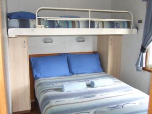 a bunk bed with a blue blanket and blue pillows at Western KI Caravan Park & Wildlife Reserve in Flinders Chase