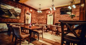 a restaurant with a brick wall and tables and chairs at Konačište Grad B&B in Užice