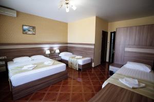 ヴィチャゼヴォにあるHotel Imera All Inclusiveのベッド2台とテーブル2台が備わるホテルルームです。