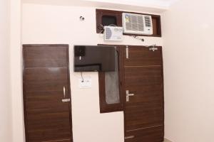 a room with two wooden doors and a microwave at Vikas Home Stay in Amritsar