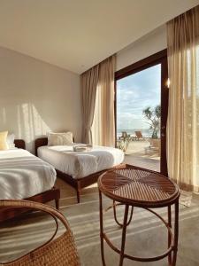 ein Hotelzimmer mit zwei Betten und einem Tisch in der Unterkunft Chula Beach Resort in Khanom