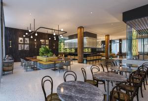 um restaurante com mesas e cadeiras e um átrio em Luminor Hotel Tanjung Selor By WH em Tanjungselor
