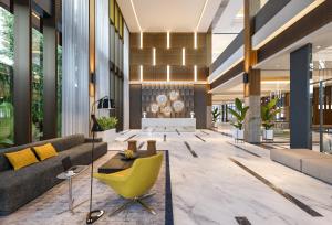 een lobby met een bank en een gele stoel bij Luminor Hotel Tanjung Selor By WH in Tanjungselor