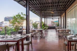 un ristorante con tavoli e sedie su un balcone di Altos Hotel a Phnom Penh