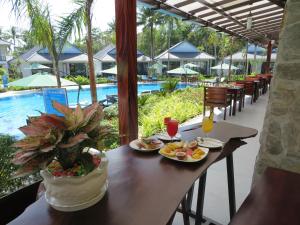 a table with plates of food on it next to a pool at Kingo Retreat Resort in Phu Quoc